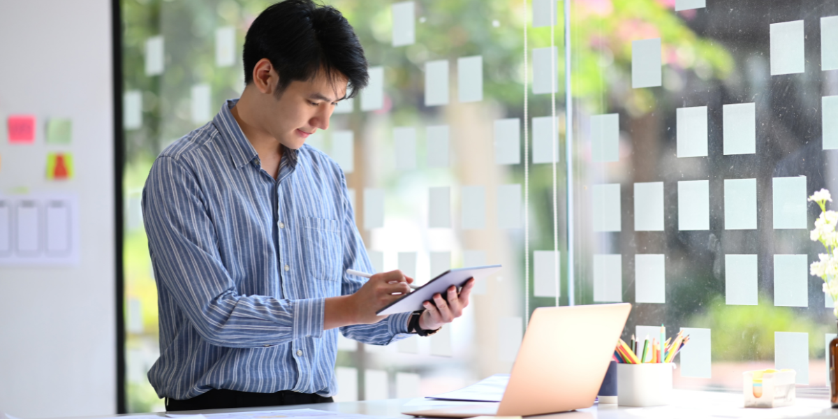 Man using a tablet and laptop