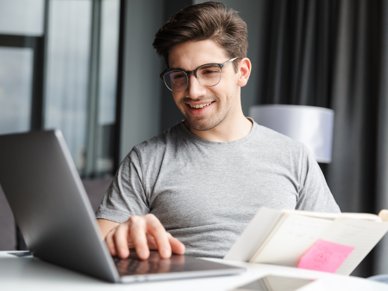 Smiling man using a laptop.